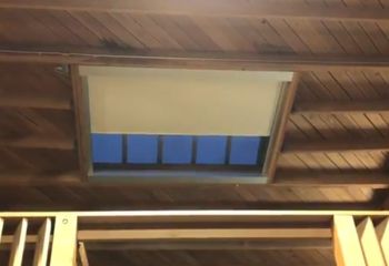 Somfy motorized skylight shades installed in a wooden ceiling of a Sherman Oaks guest house, providing automated light control and a modern look.