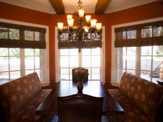 Woven wood blinds add natural elegance to a well-lit living room with large windows.