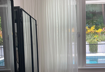 Light curtains in dining room with view to patio pool outside